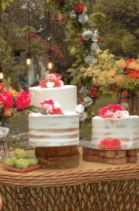two white cakes sitting on a table with flowers at Sítio Conquista Feliz in Nova Iguaçu