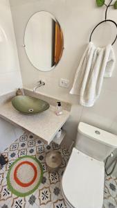 a bathroom with a sink and a toilet and a mirror at Kitinet Cunha in Cunha +23 photos
