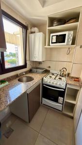 a small kitchen with a stove and a sink at Descanso Céntrico in Salta +17 photos