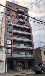 a tall brick building with a car parked in front of it at Descanso Céntrico in Salta