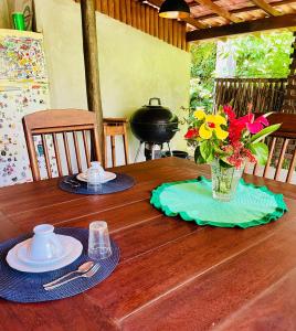 a wooden table with a vase of flowers on it at Relax Private Room - Santo André, BA in Santo André +10 photos