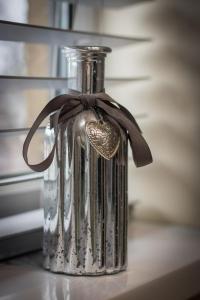 a glass bottle with a bow on a table at 6 Bed home near to Birmingham Nec Airport 6 miles from city centre in Marston Green