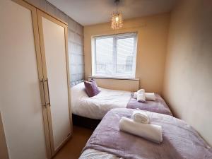 two beds in a small room with a window at 6 Bed home near to Birmingham Nec Airport 6 miles from city centre in Marston Green
