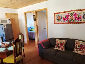 a living room with a couch and a table at Cabañas Doña Magali in Bucalemu