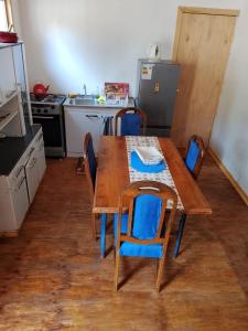 a kitchen with a wooden table with chairs and a table and a sink at Cabañas Doña Magali in Bucalemu +3 photos