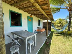 a patio with a table and chairs and a couch at OCA Caraíva in Caraíva