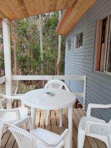 a white table and chairs on the porch of a house at Cabañas Doña Magali in Bucalemu