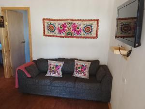 a couch in a living room with a rug on the wall at Cabañas Doña Magali in Bucalemu