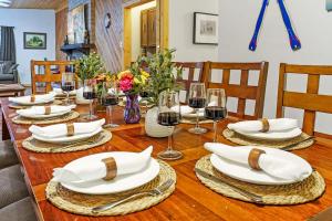 a dining room table with white plates and glasses of wine at Airy Alto Escape Deck Games Views in Sun Valley