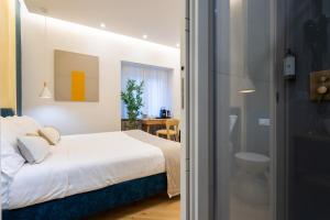 a bedroom with a white bed and a bathroom at Barberini Design Suites in Rome