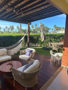 a porch with a hammock and chairs and a table at Apartamento Garden in Baixio