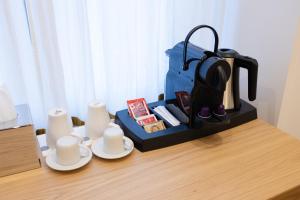 a coffee maker and two cups on a table at Barberini Design Suites in Rome