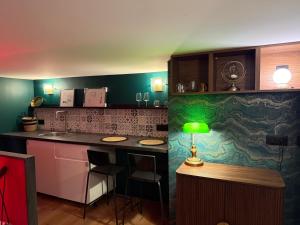 a kitchen with a green lamp on a counter at Le 1920- Spa & Sauna privé- Love Room in Le Havre