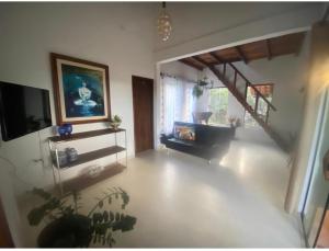 a room with a living room with a couch and a television at Casa Águas Claras in Palmeiras