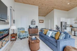 a living room with a blue couch and a table at Mtn-View 'Hidden Falls' Cabin w/ Hot Tub & Deck in Andrews
