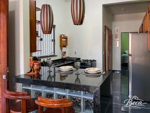 a kitchen with a counter with chairs and a refrigerator at BECA Residencial in Canoa Quebrada +14 photos