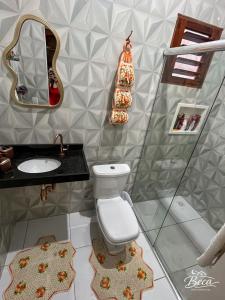 a bathroom with a toilet and a sink and a mirror at BECA Residencial in Canoa Quebrada