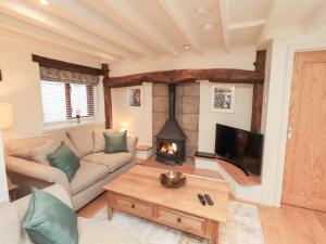a living room with a couch and a fireplace at Jasmine Cottage in Keswick
