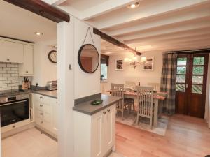 a kitchen with a table and a dining room at Jasmine Cottage in Keswick