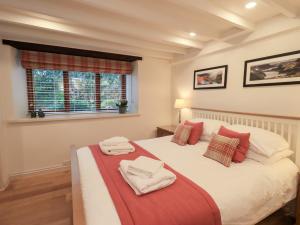 a bedroom with a bed with towels on it at Jasmine Cottage in Keswick