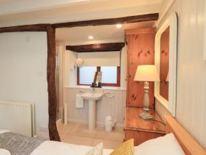 a bathroom with a bed and a sink in a room at Jasmine Cottage in Keswick +29 photos