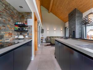 a kitchen with blue cabinets and a brick wall at Alpinn Wellness 2 in Sankt Margarethen im Lungau
