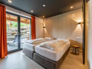 a bedroom with two beds and a large window at Alpinn Wellness 2 in Sankt Margarethen im Lungau