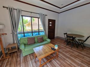 a living room with a green couch and a table at Rim Khao Jungle Resort Koh Lanta in Ko Lanta