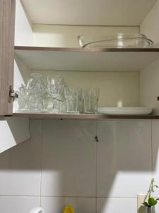 a shelf with glasses on it in a kitchen at Apartamento vita bella in Porto Velho