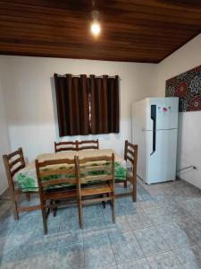 a kitchen with a table and chairs and a refrigerator at Chácara Rancho Imperial - Socorro - SP - Piscina, Churrasqueira, Forno à Lenha, Campo de Futebol e uma linda Vista para a Montanha! in Socorro