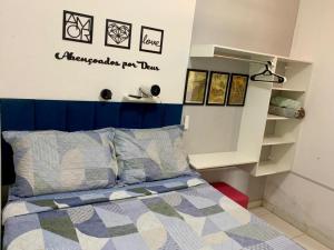 a bedroom with a bed with a blue headboard at Quarto privativo La Paz in Aracaju