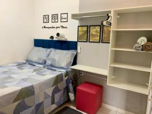 a bedroom with a bed and a red suitcase at Quarto privativo La Paz in Aracaju