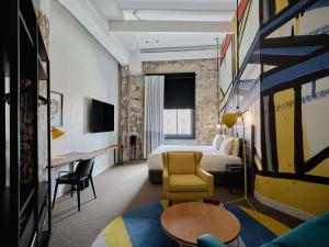 a hotel room with a bed and a desk at Hotel Woolstore 1888, Sydney - Handwritten Collection in Sydney