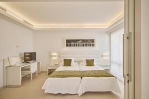 a white bedroom with two beds and a desk at Hotel Argos Ibiza in Talamanca +109 photos