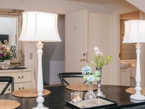 two white lamps on a table with flowers on it at Spacious holiday home with garden in Skanderborg