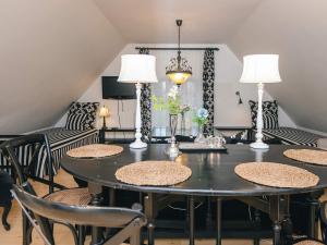 a dining room with a black table and chairs at Spacious holiday home with garden in Skanderborg
