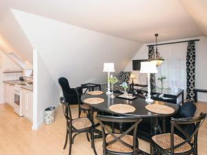 a dining room with a black table and chairs at Spacious holiday home with garden in Skanderborg