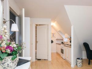 a kitchen and a living room with a vase of flowers at Spacious holiday home with garden in Skanderborg