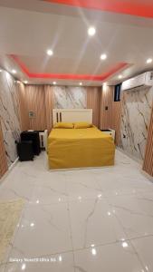 a bedroom with a yellow bed in a room with marble walls at Obynb in Santo Domingo