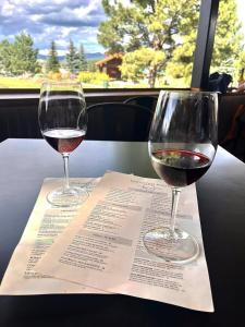 two glasses of wine sitting on top of a menu at High Pines Haven in Angel Fire