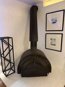 a black stove in a room with pictures on the wall at High Pines Haven in Angel Fire
