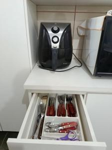 a black appliance sitting on top of a refrigerator at Refúgio Sereno São Seba in São Sebastião