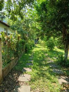a garden path with trees and a fence at Refúgio Sereno São Seba in São Sebastião