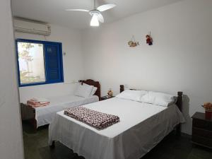 a bedroom with two beds and a window at Refúgio Sereno São Seba in São Sebastião