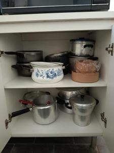 a shelf with many pots and pans on it at Refúgio Sereno São Seba in São Sebastião +19 photos