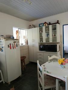 a kitchen with a table and a refrigerator at Refúgio Sereno São Seba in São Sebastião