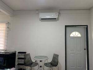 a room with chairs and a table and a white door at Villa Nola Tres in Port-of-Spain +3 photos