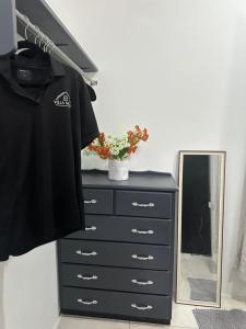 a black dresser with a mirror and a black shirt at Villa Nola Tres in Port-of-Spain