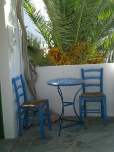 zwei blaue Stühle, ein Tisch und zwei Stühle in der Unterkunft Teresa Spiti in Adamas