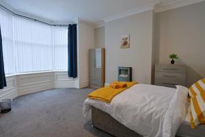 a bedroom with a bed with a yellow blanket on it at Elevate suites Darlington in Darlington